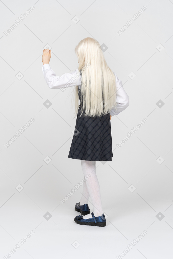 Vista traseira de uma estudante levantando a mão