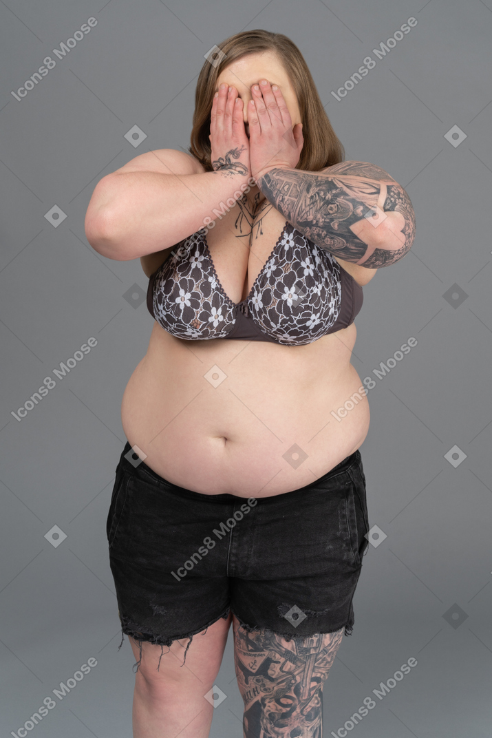 Plump woman hiding face with arms