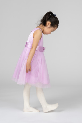 Menina em um vestido rosa assistindo seu passo