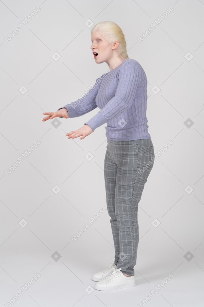 Young woman raising hands and looking afraid