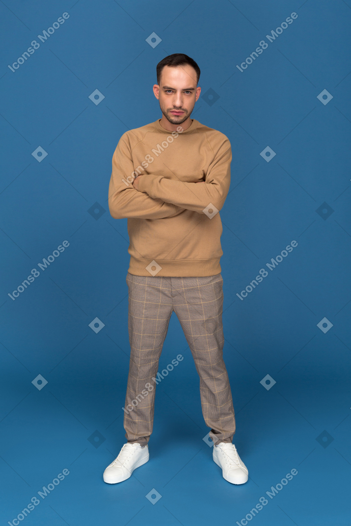 Young man standing with hands crossed
