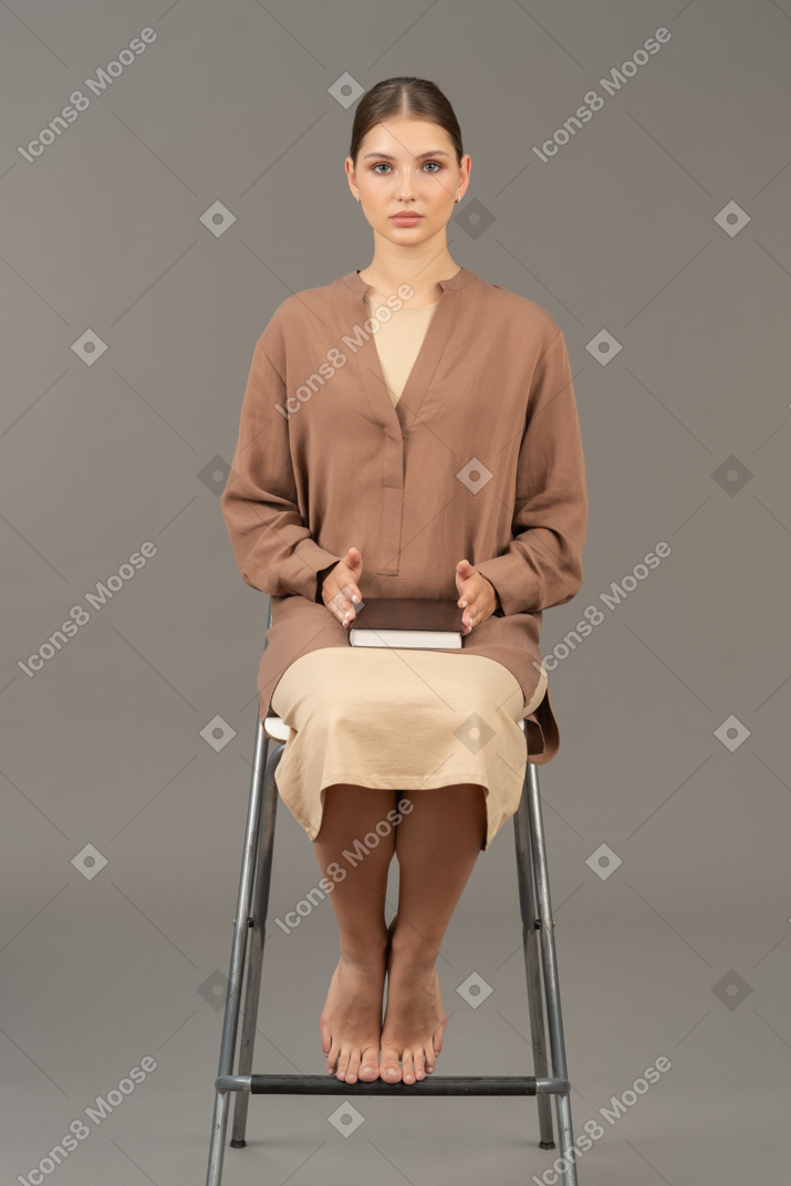 Young woman looking at camera while sitting