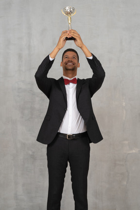 Man holding up award in celebration of his win