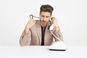 Hombre joven guapo con receptor de teléfono cerca de su oreja