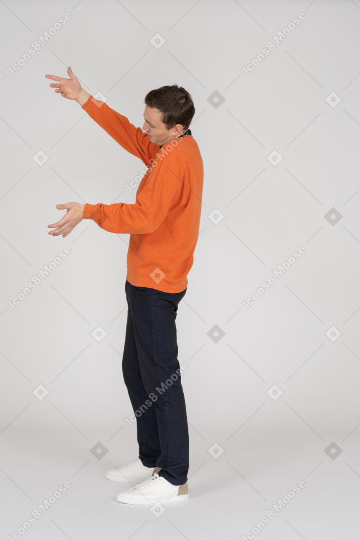 Junger mann im orangefarbenen sweatshirt stehend