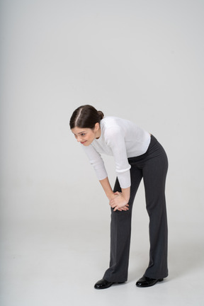 Front view of a woman in suit bending down