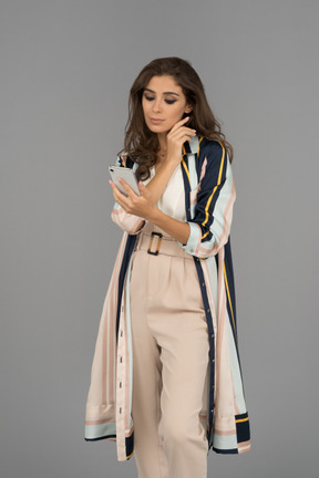 Серьезная ближневосточная женщина смотрит на свой телефон