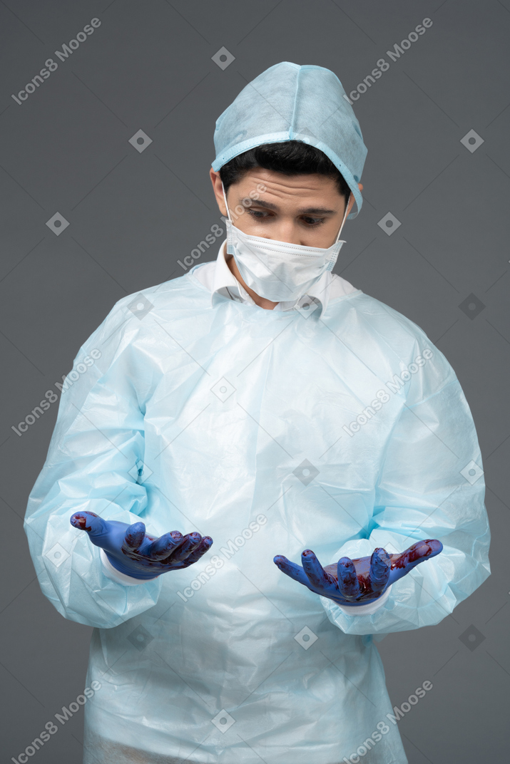 Doctor looking at his bloody hands