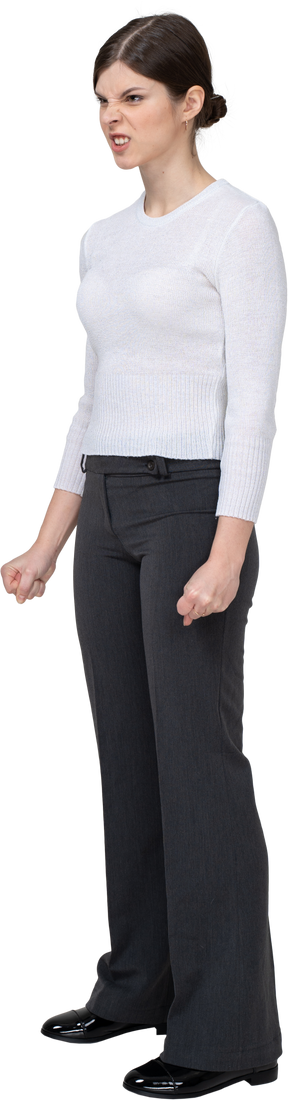 Three-quarter view of a furious woman in office clothing clenching fists