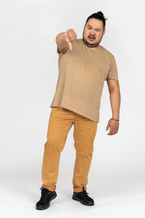 Expressivo homem asiático mostrando o polegar para baixo