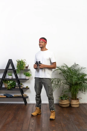 Good looking young man holding binoculars