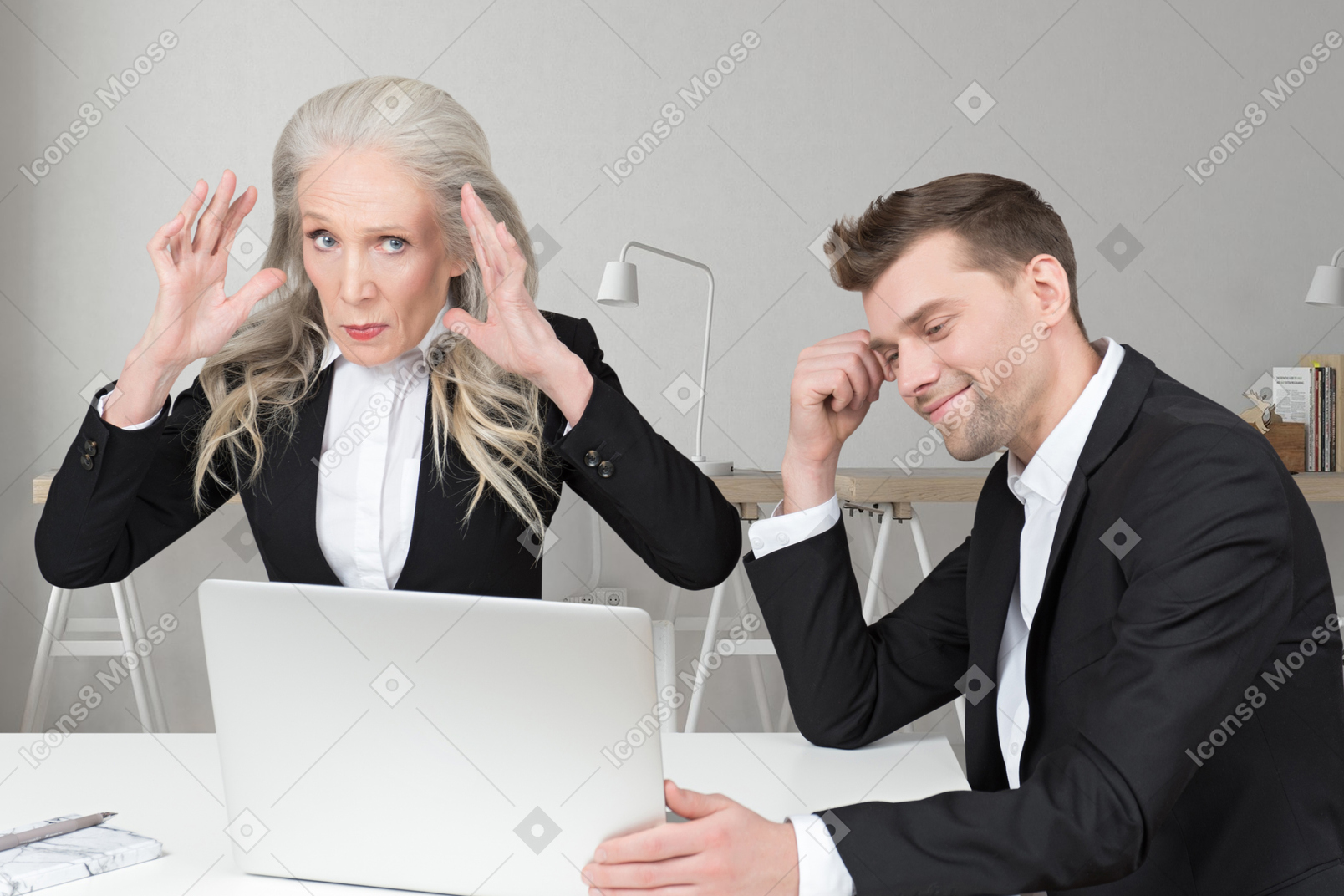 Man and sitting at laptop near disgruntled woman