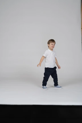 Little boy standing with arms at sides