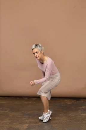 Side view of a woman in casual clothes showing a warning gesture
