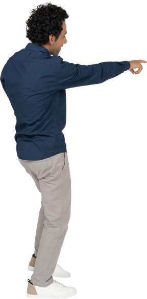 Side view of a man in casual clothes pointing with a finger