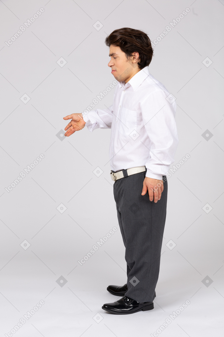 Young man in business casual clothes gesturing with eyes closed