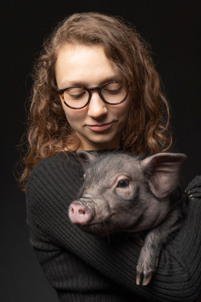 Hermosa chica con cerdo en miniatura