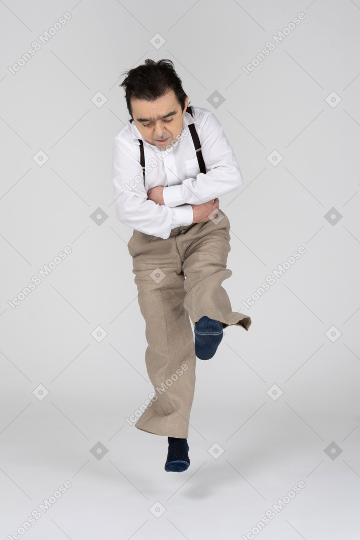 Man in socks jumping with crossed arms