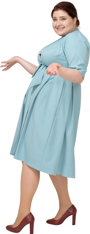 Вид сбоку счастливой женщины в синем платье жесты