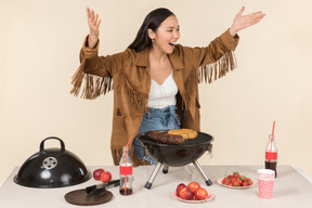 Young asian girl having problem with barbecue