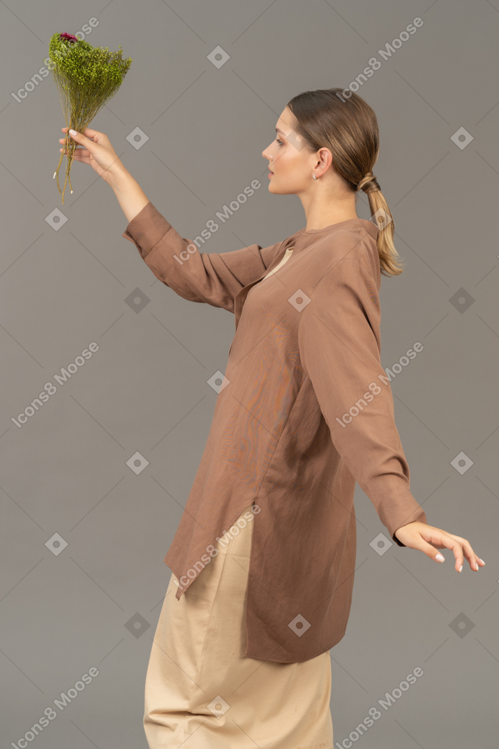 Side view of a woman holding flowers