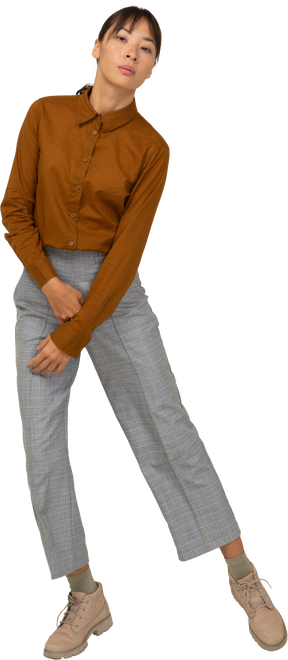Vista frontale di una giovane donna asiatica che balla in calzoni e camicetta
