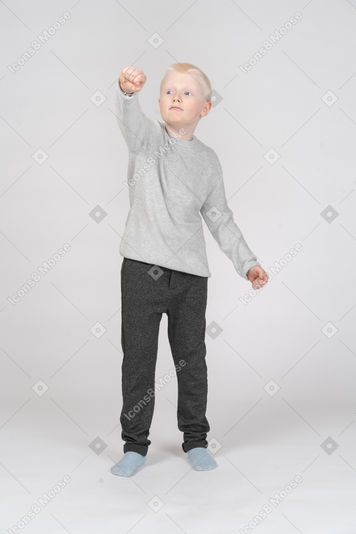 Front view of a boy with fist up in the air