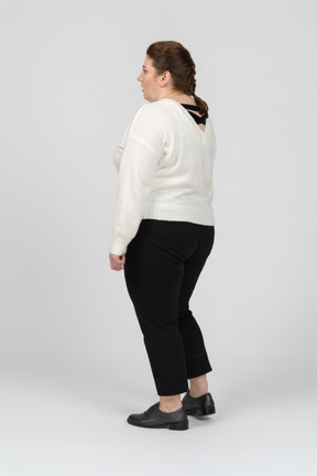 立っている白いセーターのプラスのサイズの女性