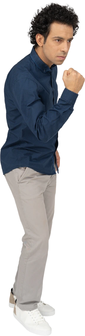 Side view of a man in casual clothes showing fist