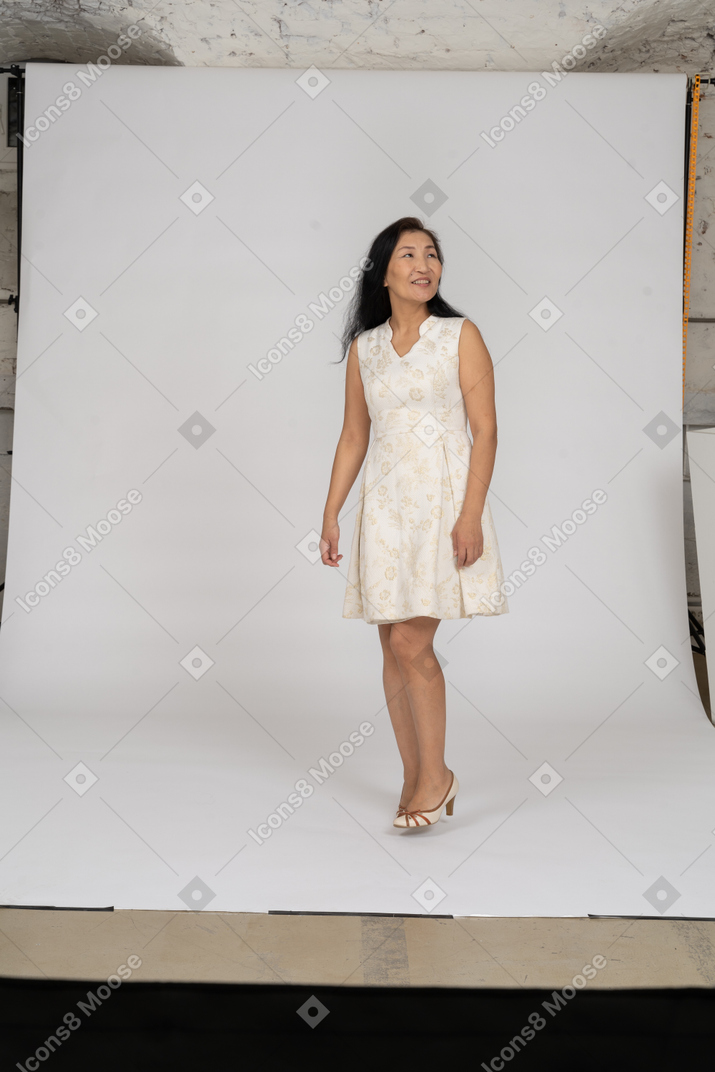 Femme en robe blanche debout