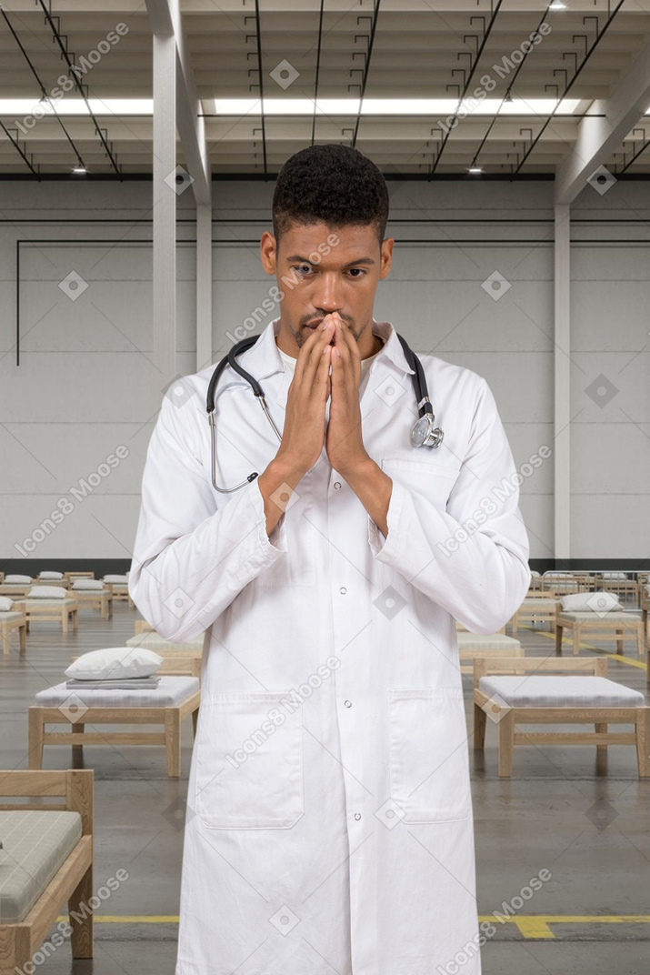 Thoughtful doctor holding hands near face