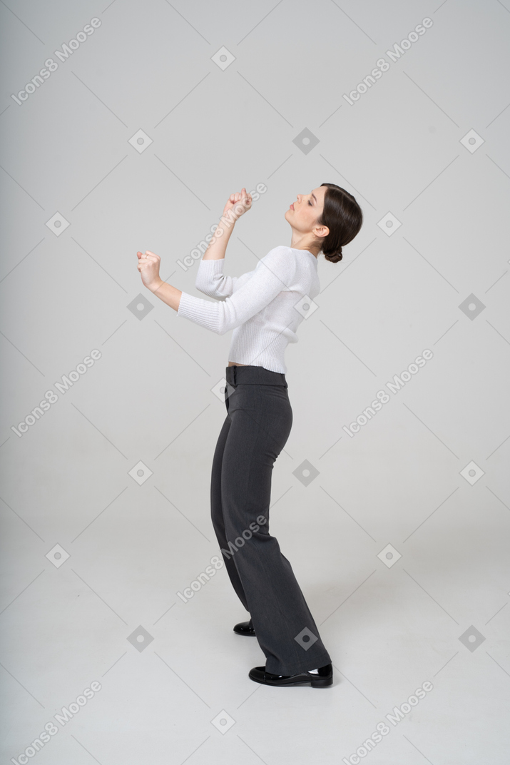 Vista lateral de uma mulher de terno dançando