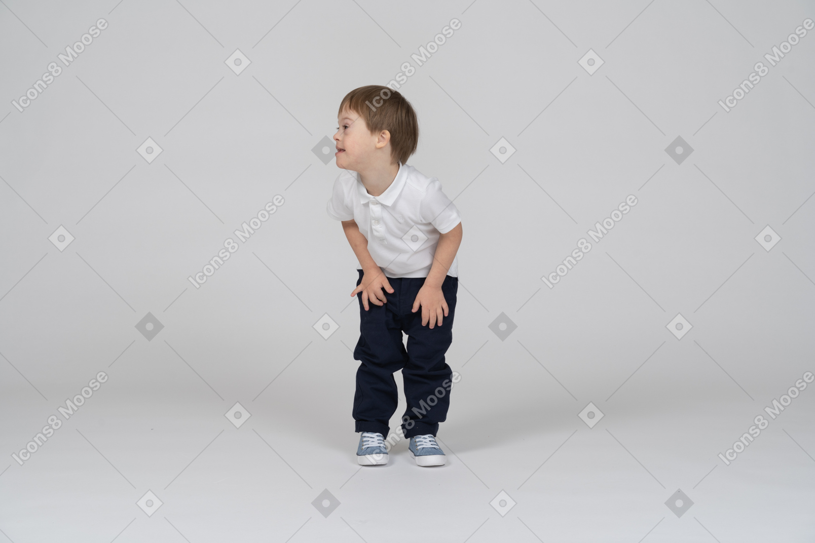 Vista frontal del niño inclinado hacia adelante y mirando a un lado