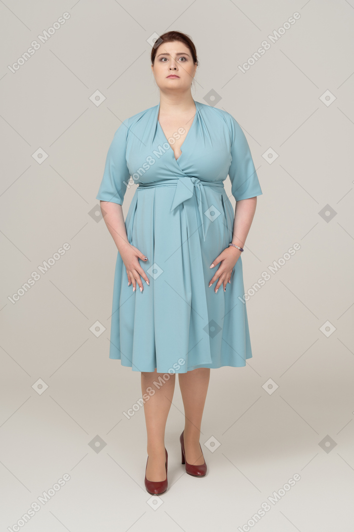 一个穿着蓝色连衣裙的女人看着相机的前视图