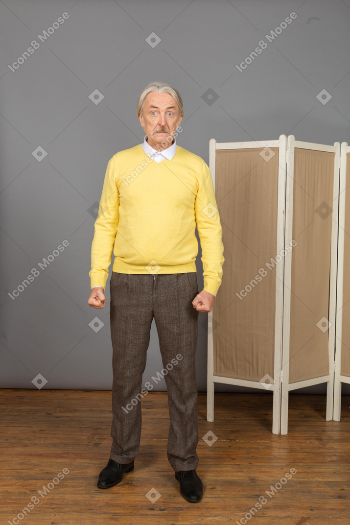 Vue de face d'un vieil homme impatient serrant les poings