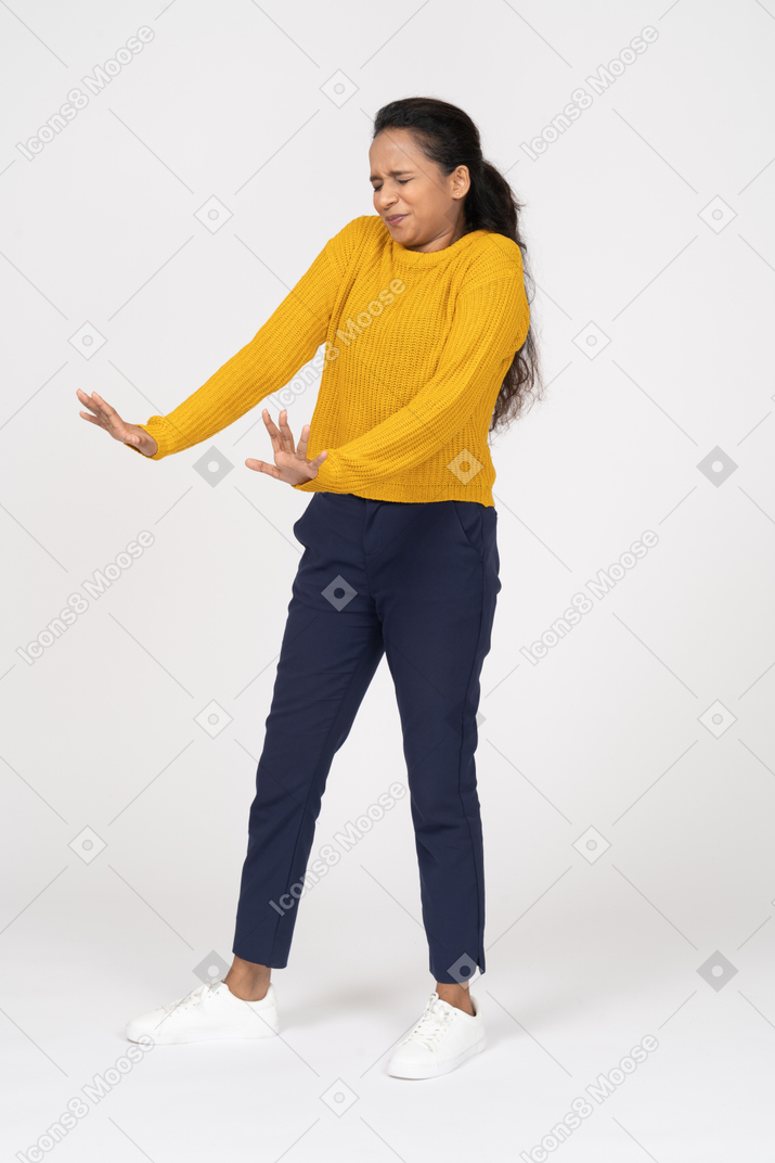 Vista frontal de uma garota assustada em roupas casuais mostrando um gesto de pare
