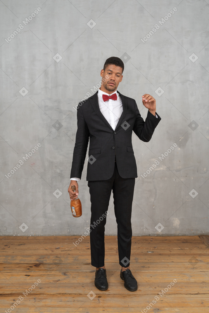 Uomo brillo in piedi con una bottiglia di champagne in mano