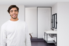 A man standing in a bathroom next to a sink