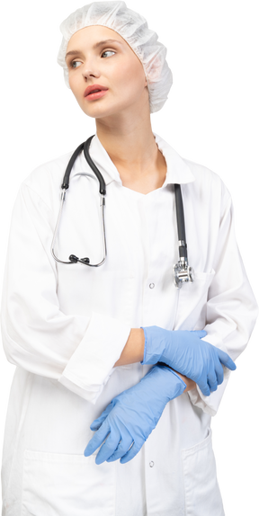 Vista frontale di una giovane dottoressa stanca con lo stetoscopio che si tiene per mano insieme