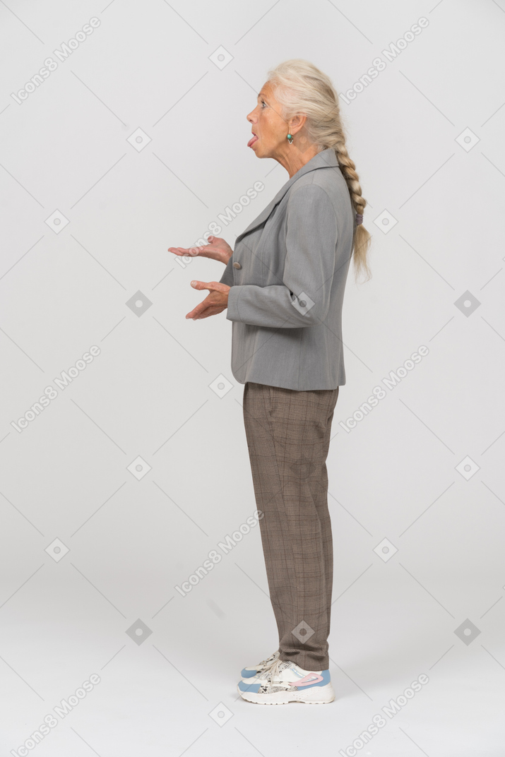 Вид сбоку на пожилую женщину, жестикулирующую и показывающую язык