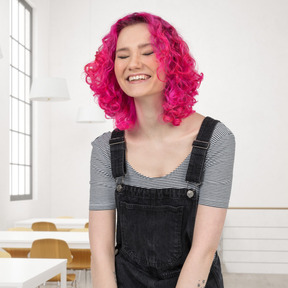 A young woman with pink hair laughing in the classroom