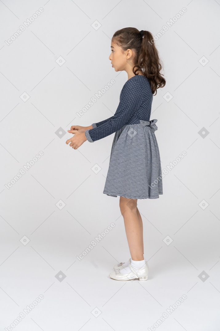 Side view of a girl reaching out with her hands in shock