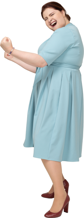 Vista lateral de uma mulher feliz em um vestido azul gesticulando