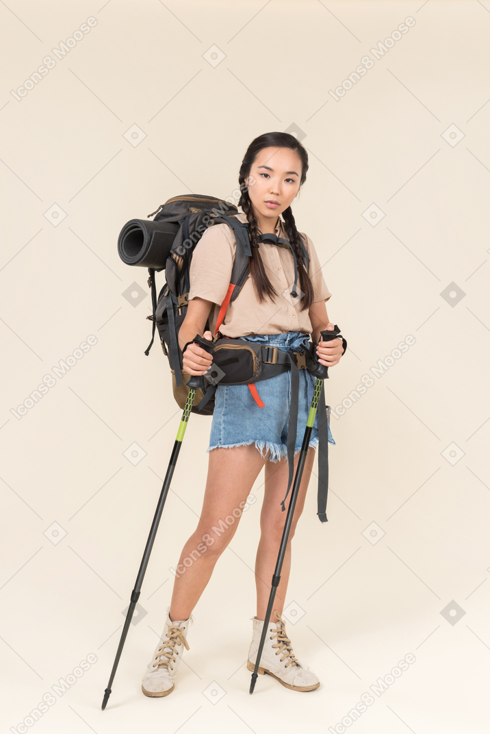 年轻的徒步旅行者女人走路使用登山杆
