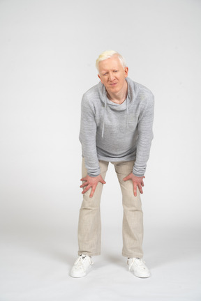 Front view of a man touching knees