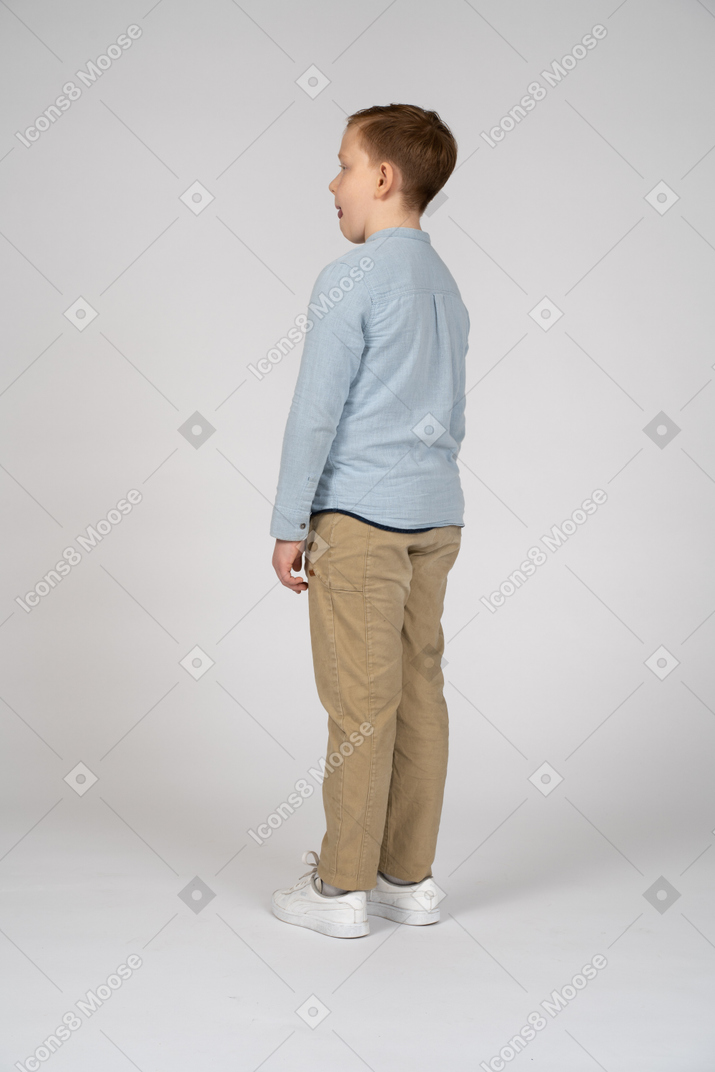 Side view of a boy in casual clothes licking lips