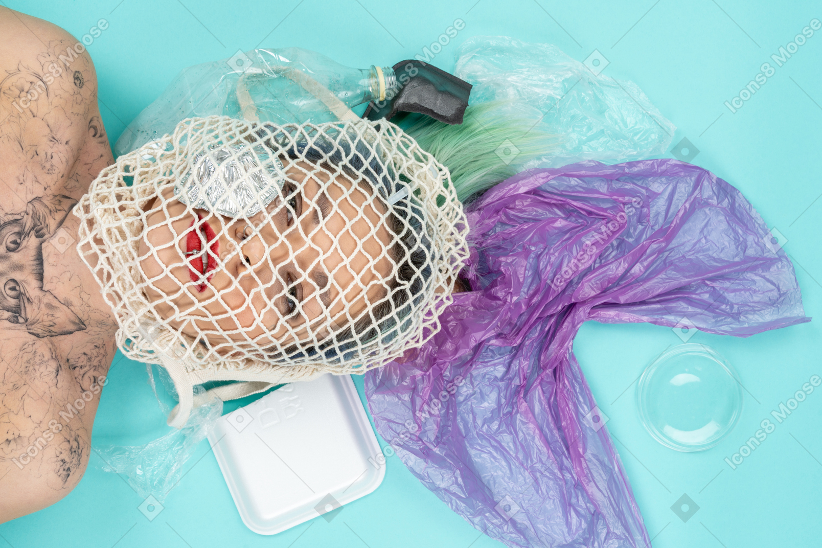 Young woman lying down with her face covered with plastic trash