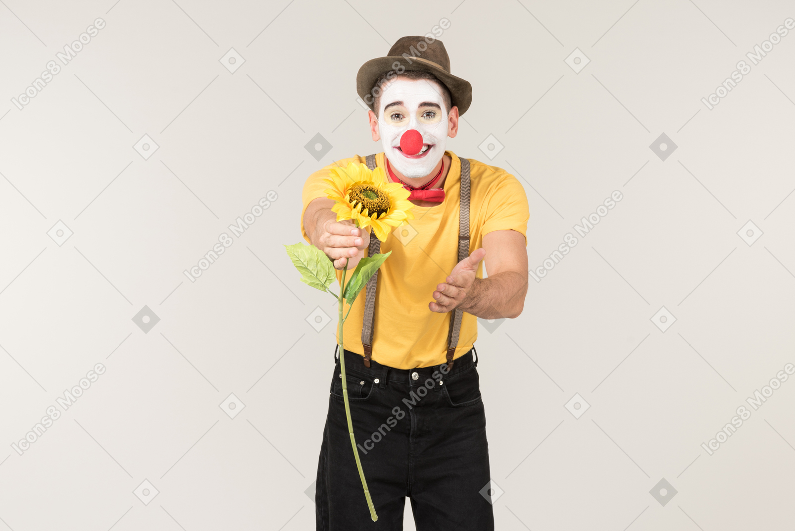 Male clown passing on a sunflower