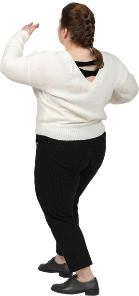 Rear view of a plump woman in casual clothes posing