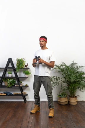 Good looking young man holding binoculars